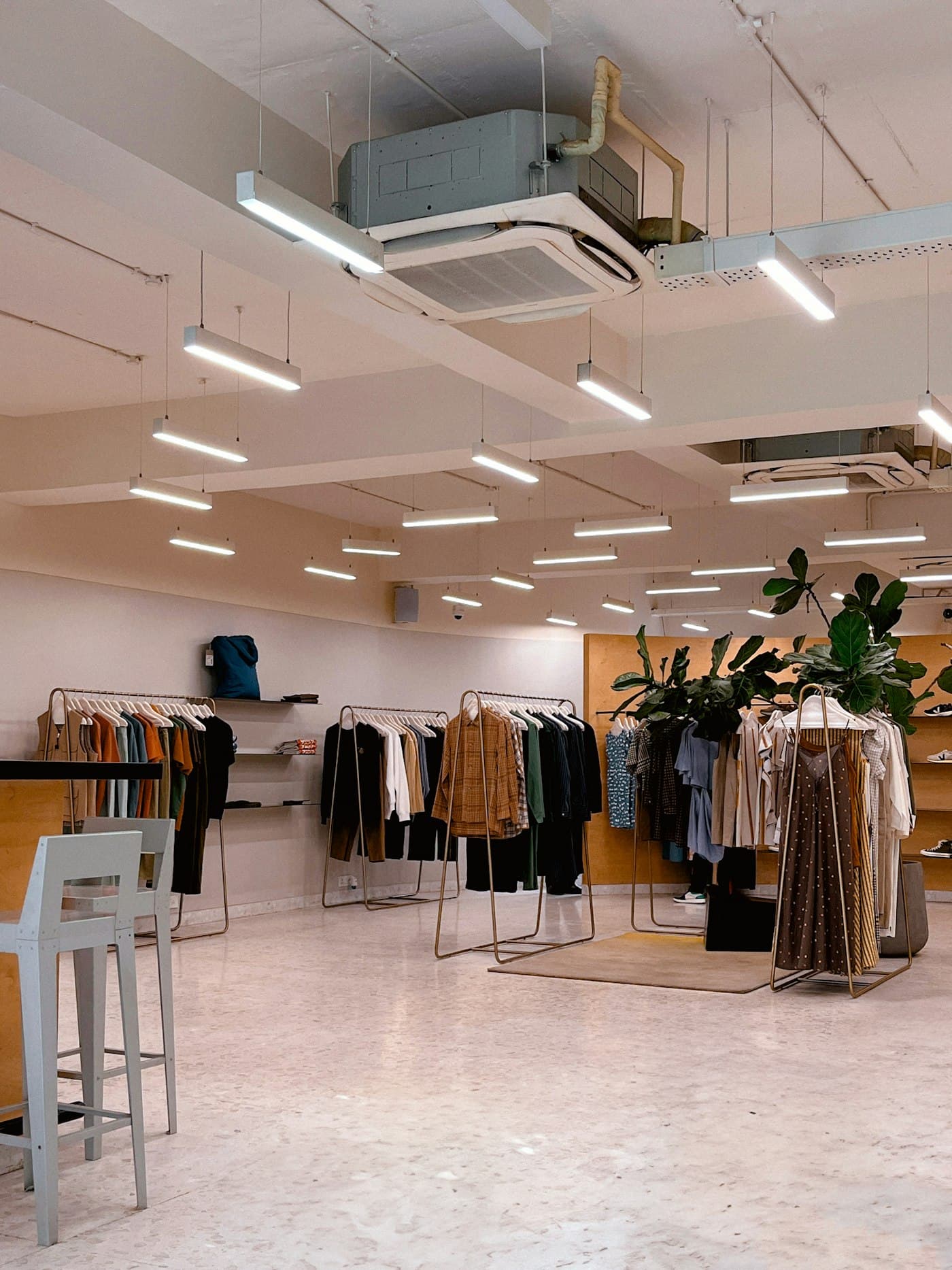 Bright, minimal clothing boutique interior with rails of garments